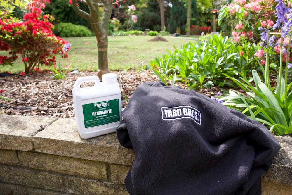 Yard Bros product and branded jacket on a stone ledge with a garden background